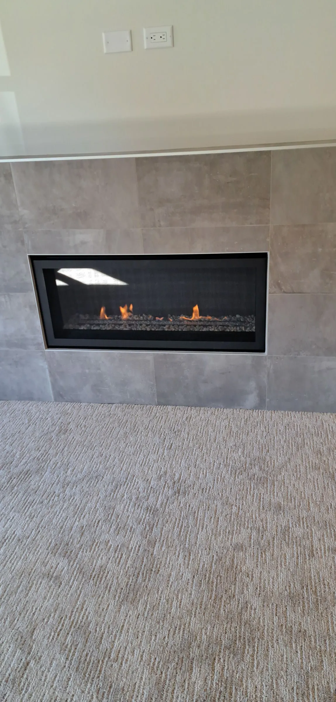 Finished linear gas fireplace with a large-format tile surround