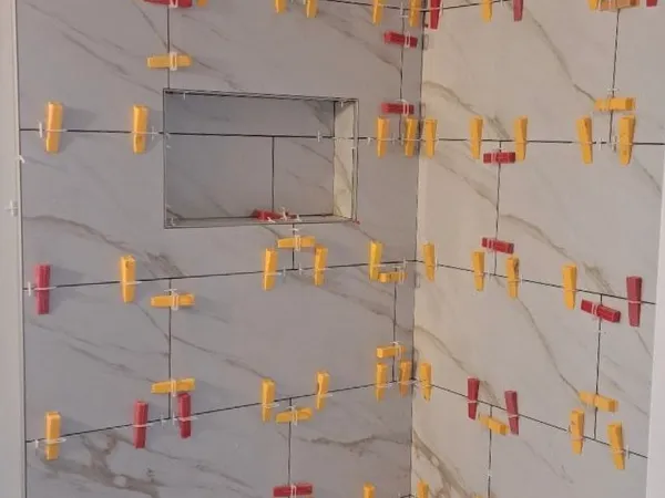 Tile levelling clips and spacers holding a floor dead flat